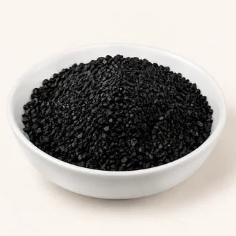 A white bowl of black activated carbon granules.