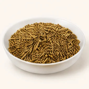 A white bowl of brass coloured KDF filtration granules.